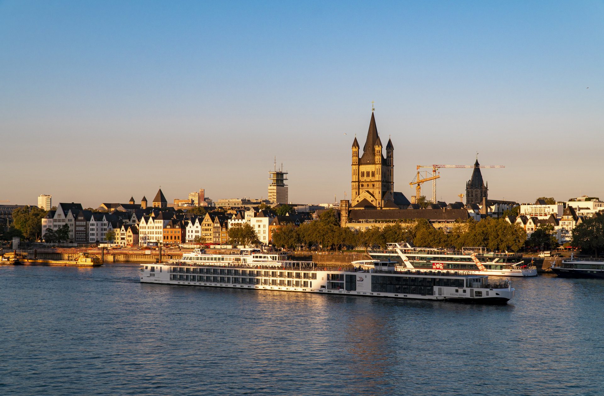 A river cruise ship moored below the old town of Cologne on the Rhine at sunrise